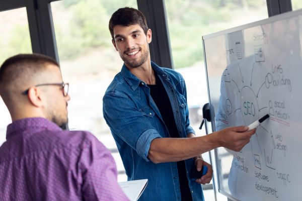 business-young-man-pointing-on-whiteboard-while-di-2022-12-15-18-19-03-utc.jpg